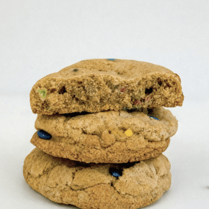 3 M&M chunky cookies with the top cookie broken in half with a clear visual of the contents inside