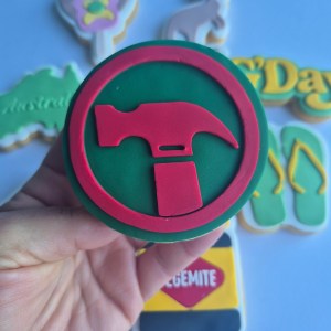 Australia day style cookie designs. the one in focus is the Bunnings logo, in the background there are an assortment of other styles such as a kangaroo, thongs, a Vegemite jar, and others.